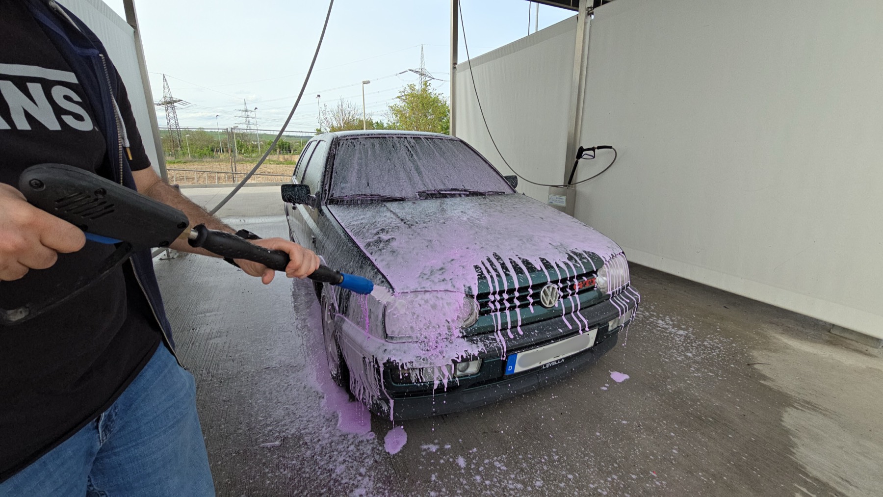 VW Golf wird in der Waschbox mit Intensivschaum eingesprüht